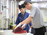 鮮魚の加工作業です。誰にでもできる作業を一通り覚え鮮魚の加工担当になったら、まず包丁の持ち方から「下から○cmの高さに包丁を○mmの角度であてて」と基本的な作業を説明しながら先輩スタッフがお手本を見せます。