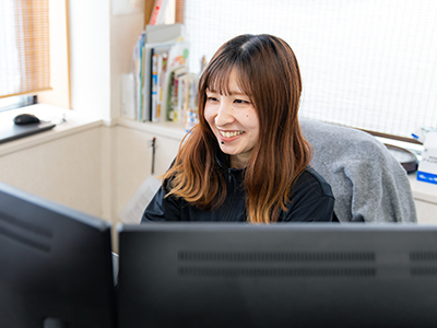 写真：竹村さんが複数のモニターを前にタイピングする様子