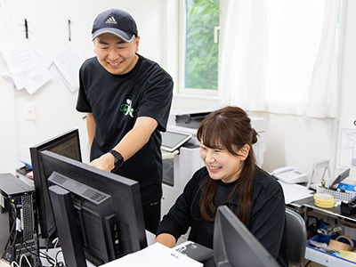 写真：菅野さんが利用者さんとお話しながら楽しく仕事をしている様子